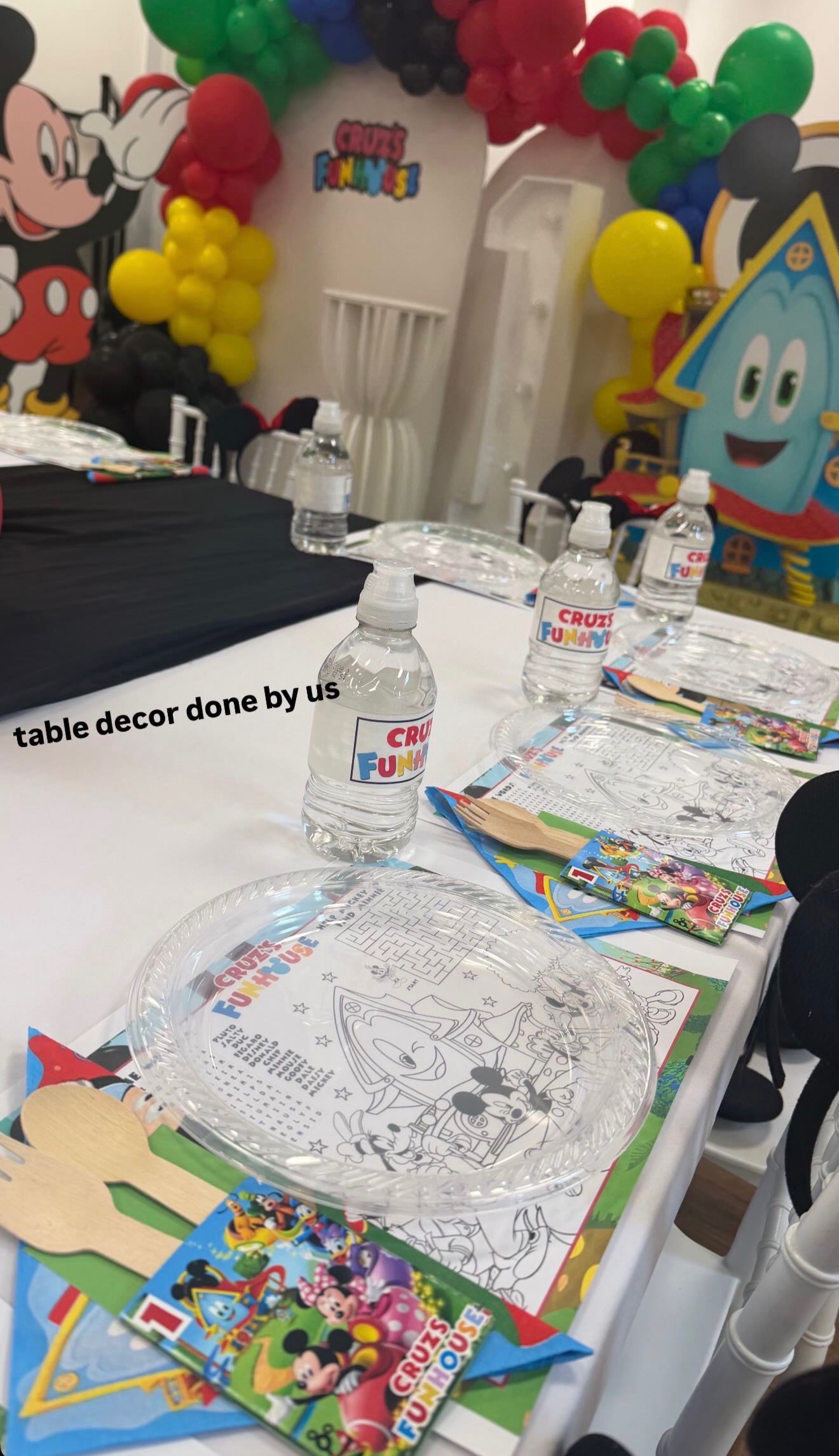 A coordinated children’s party table with activity sheets, favours and personalised water bottles